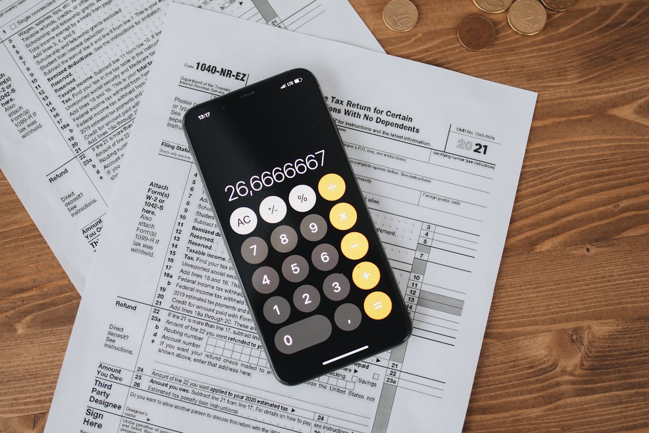 Home Overhead view of smartphone calculator on tax forms for finance and accounting.